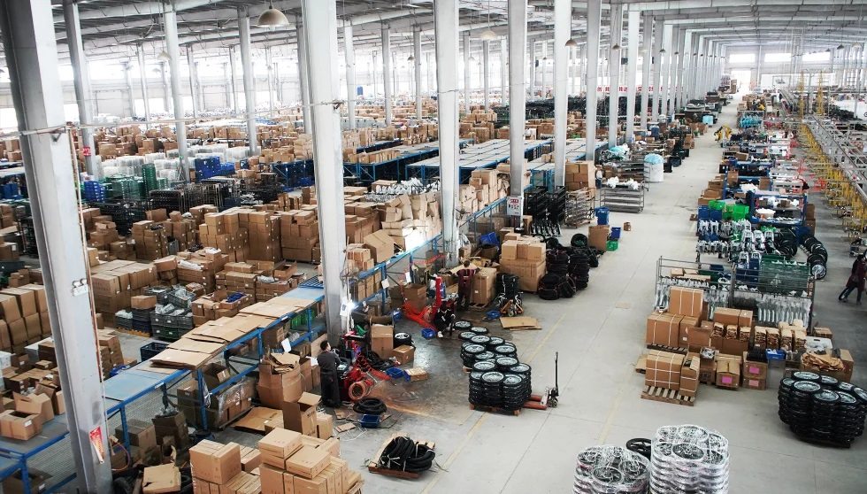 FCDC Motor factory parts staging area with wheels, cartons, and motorcycle components prepared for assembly
