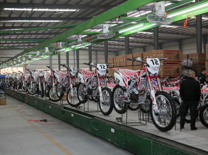 FCDC Motor dirt bikes lined up on a production line before final quality checks